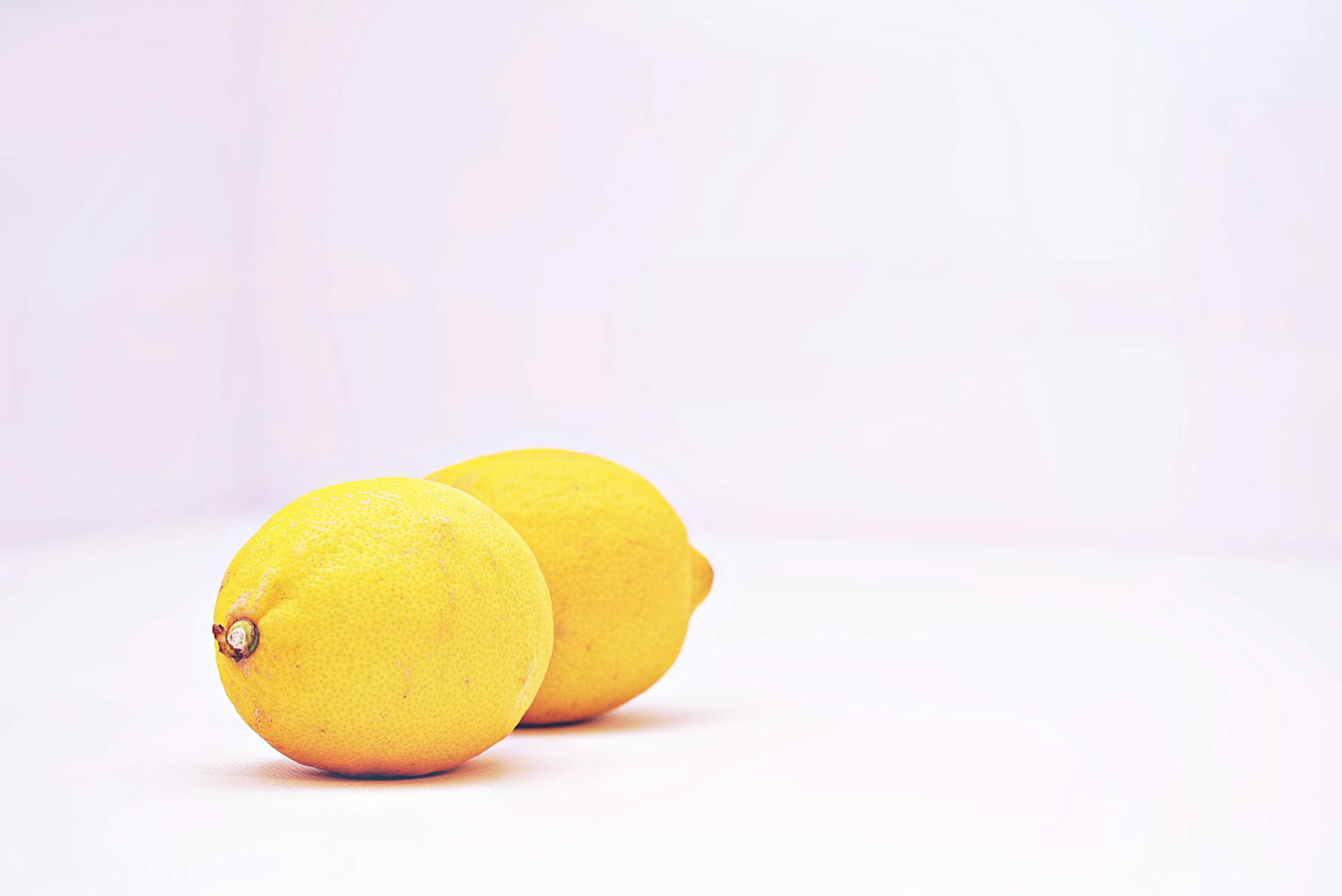 Two vibrant lemons on a white background, symbolizing freshness and renewed vitality