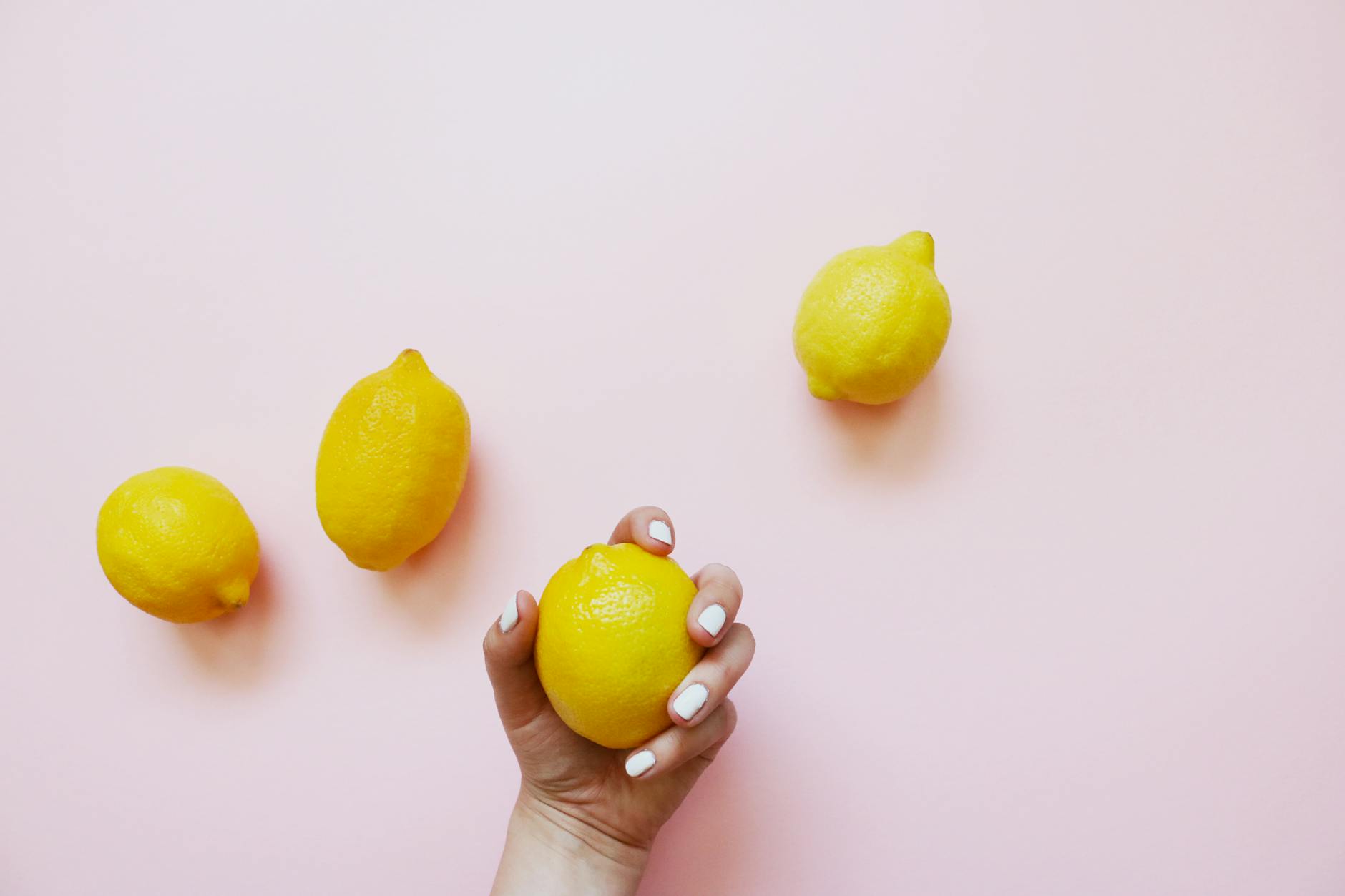 Fresh lemons on a soft pink background symbolizing renewal and intimacy after medication adjustments