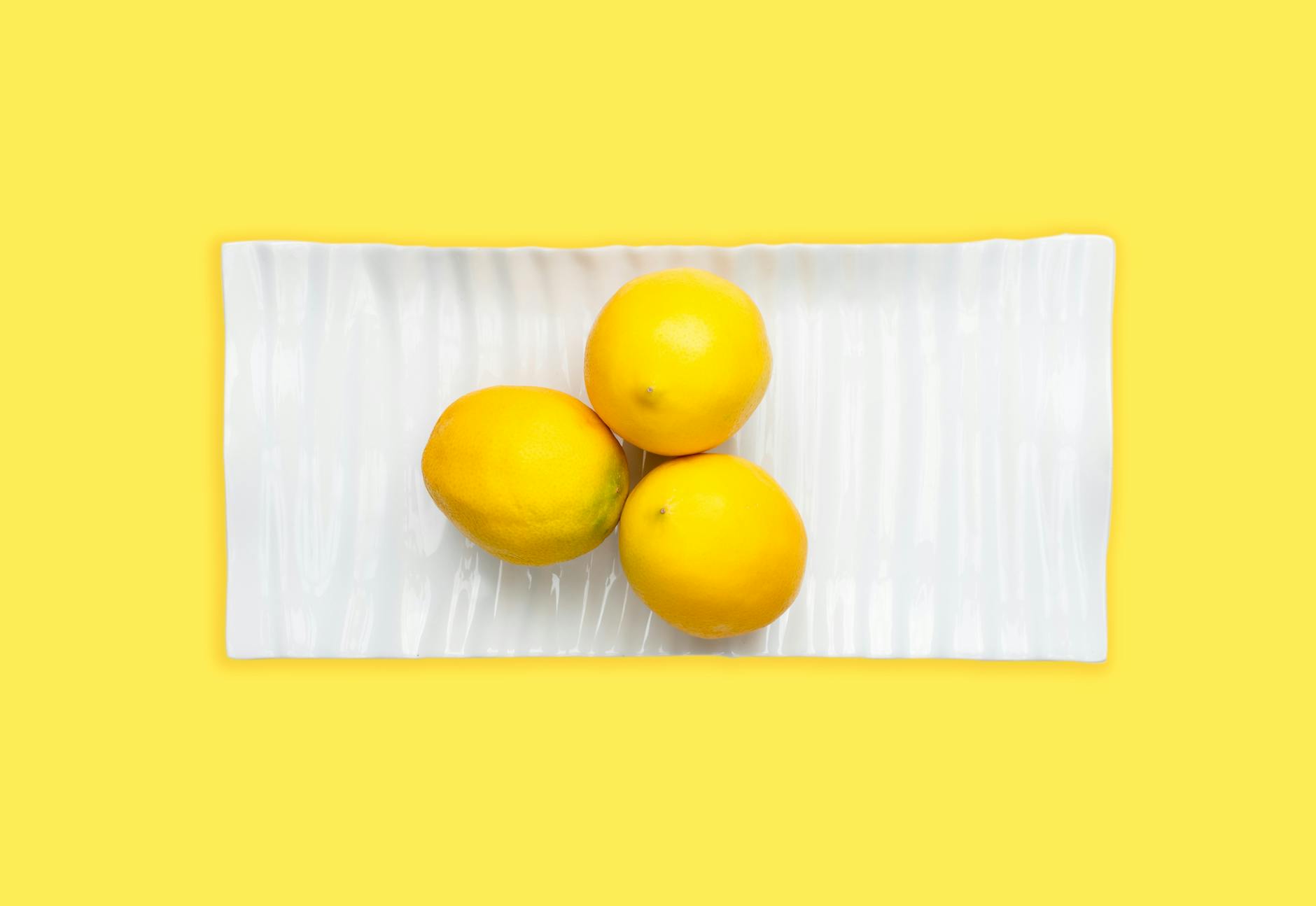 Fresh lemons stacked with books on a white tablecloth, symbolizing patience and recovery.