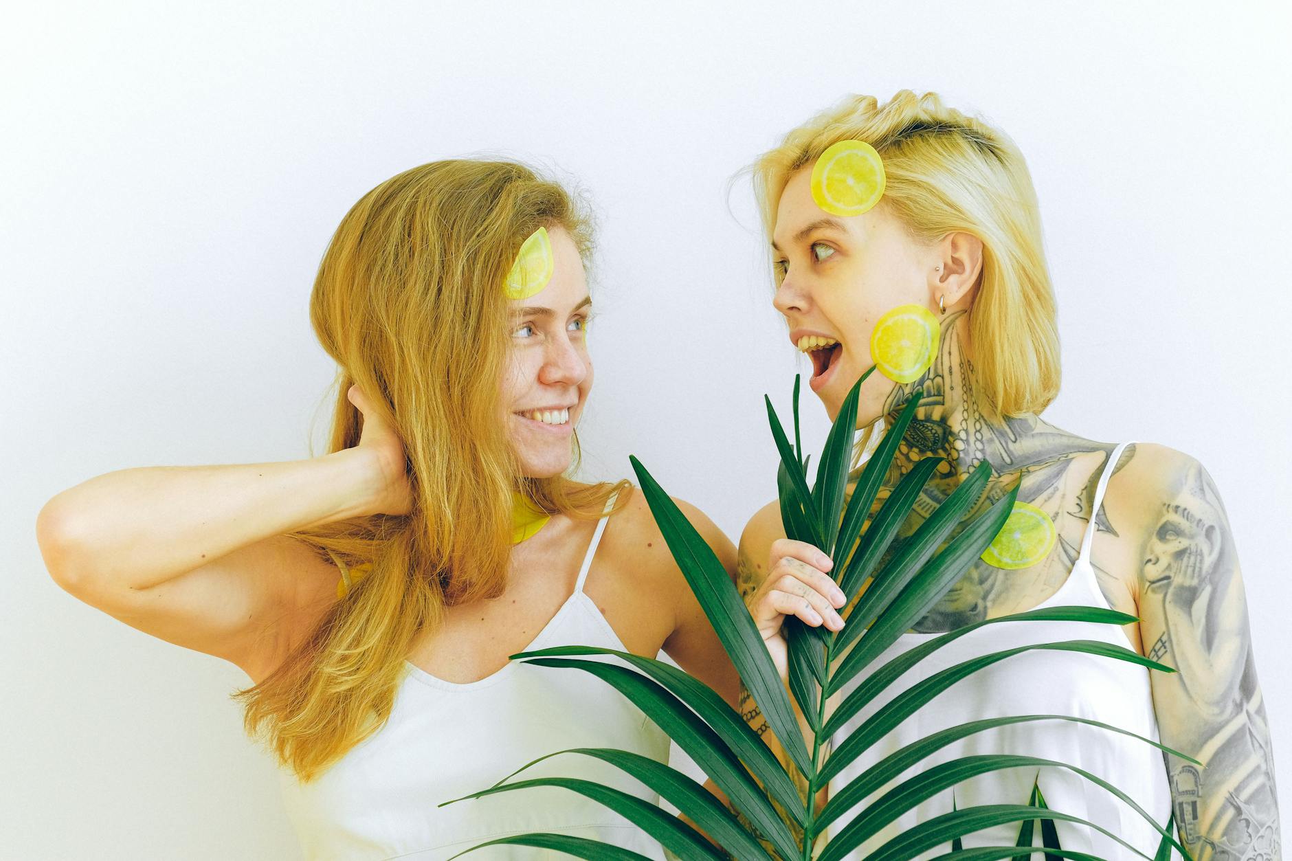 Two women smiling together with fresh lemons, expressing joy and connection indoors