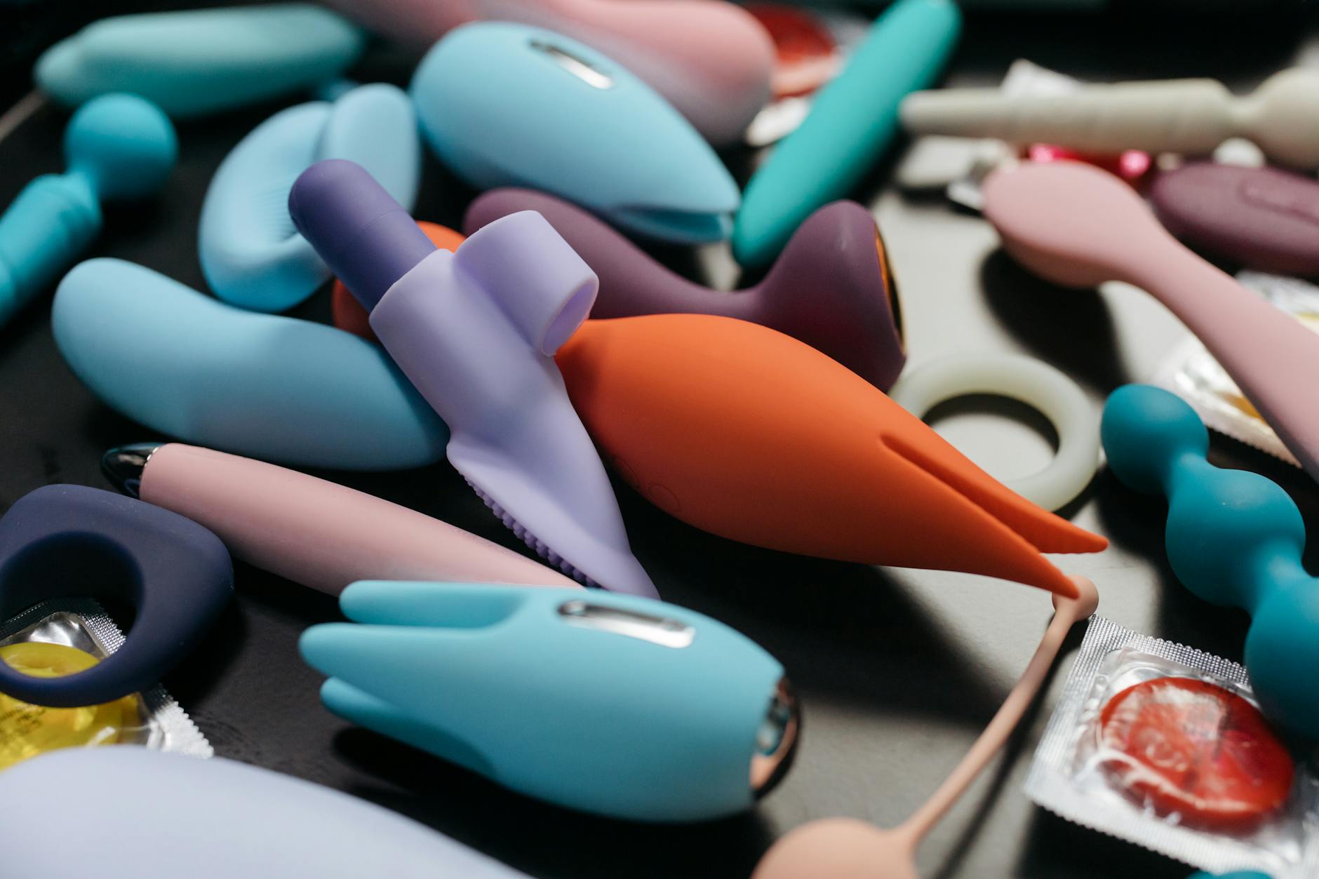 Array of colorful vibrators including lemon clitoral suction toys displayed on white surface