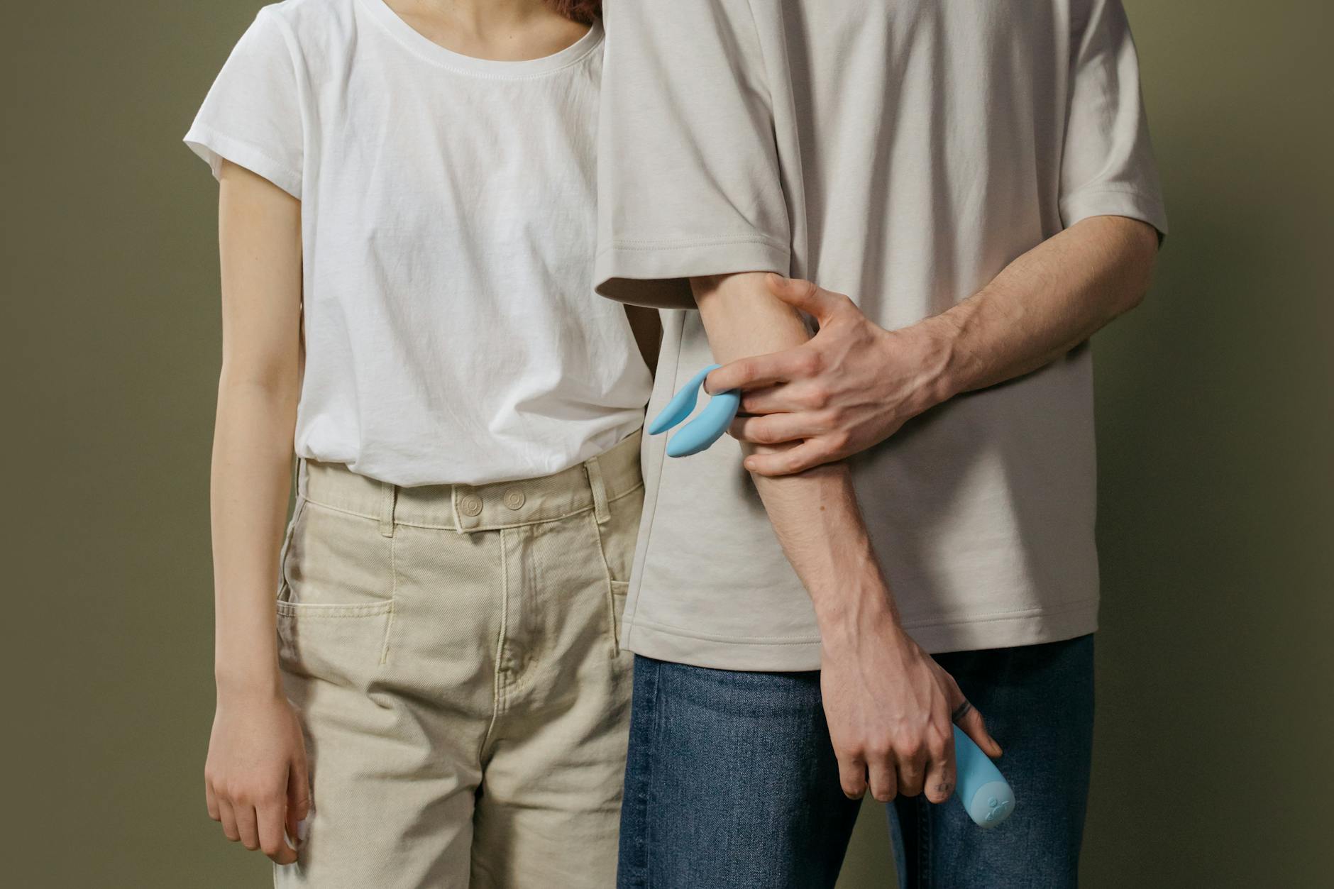 Woman holding colorful clitoral vibrators, exploring pleasure after pelvic floor pain